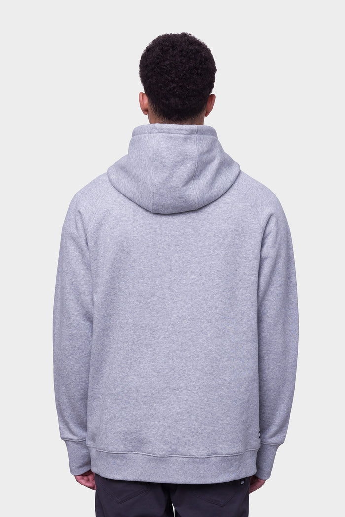 A person with short curly hair is seen from the back wearing the 686 Mens Knockout Pullover Hoody in light gray and dark pants, set against a plain white background.