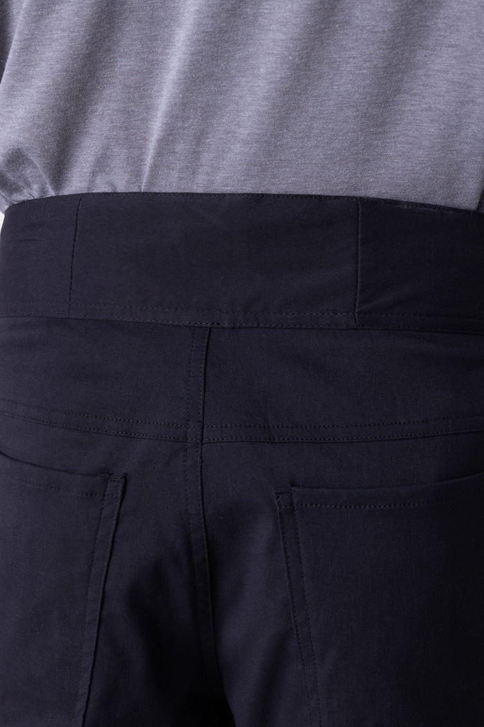 Close-up of a person wearing the 686 Mens Platform Bike Pant - Relaxed Fit, showcasing the waistband, seams, and back pockets of these high-waisted black pants from 686.
