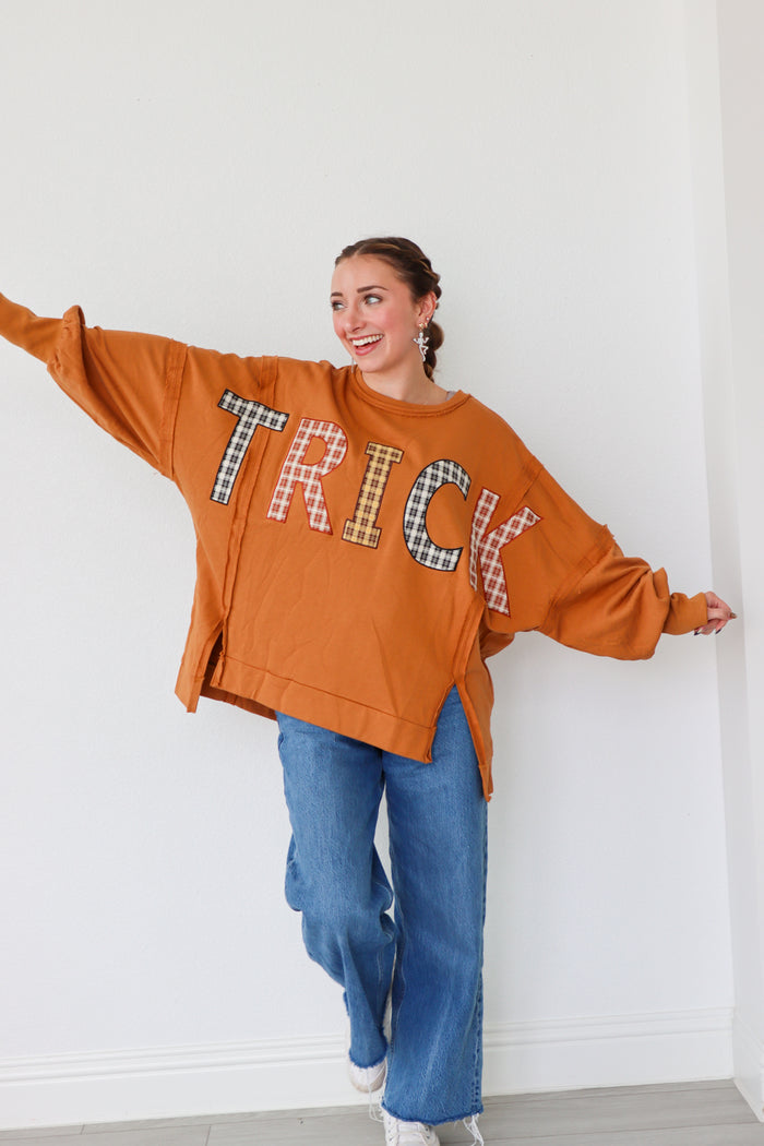 girl wearing orange long sleeve "trick" top