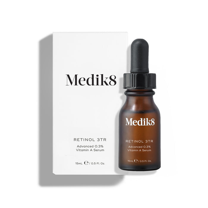 Medik8 Retinol 3TR serum bottle and its white cardboard carton displayed on a clean white background with soft shadows. The amber glass bottle with a black dropper cap and the white box both feature the Medik8 logo and identify the product as "RETINOL 3TR Advanced 0.3% Vitamin A Serum" in a 15mL size.
