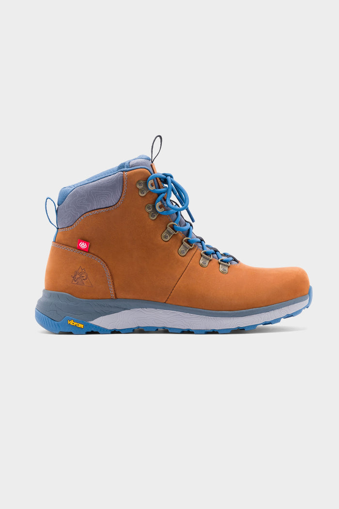 The 686 x Rocky Boots Mens Summit Elite Boot by 686 features a tan and blue design with blue laces and sole, metal eyelets, and ankle support. Shown in side profile on a plain light background.
