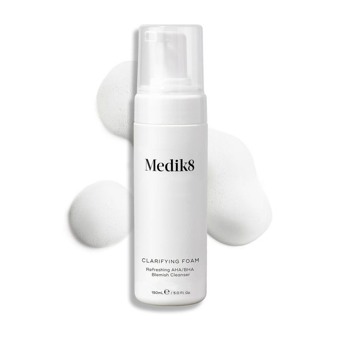Medik8 Clarifying Foam pump bottle displayed on a clean white background with three dollops of white airy foam. Text identifies it as a Refreshing AHA/BHA Blemish Cleanser in a 150mL size.