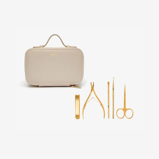A beige faux leather nail kit case with a top handle, shown alongside five gold-colored metal nail tools on a clean white background. The brand name 'NUI.