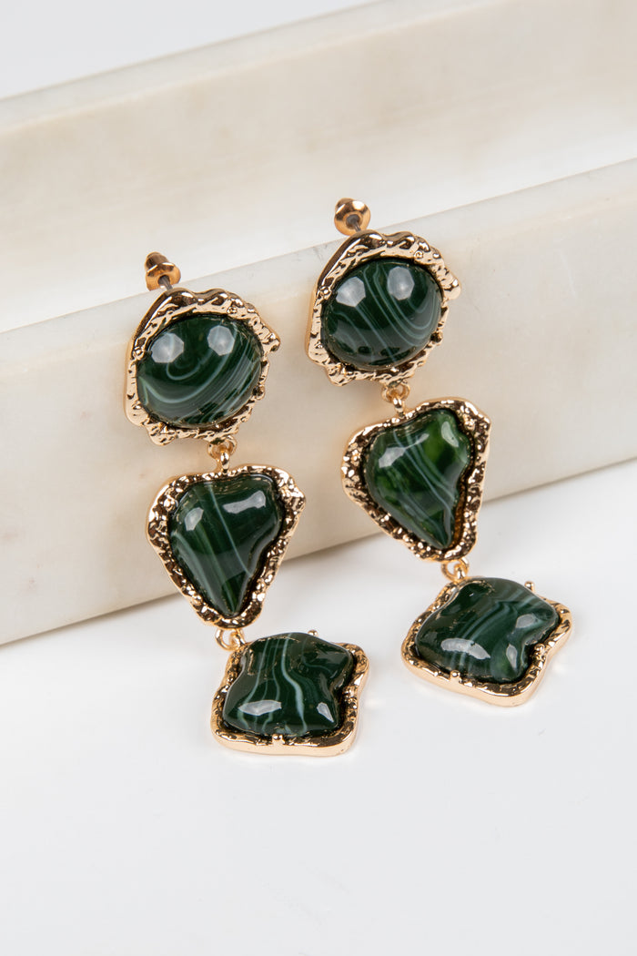 Green gemstone earrings with gold accents on a white background