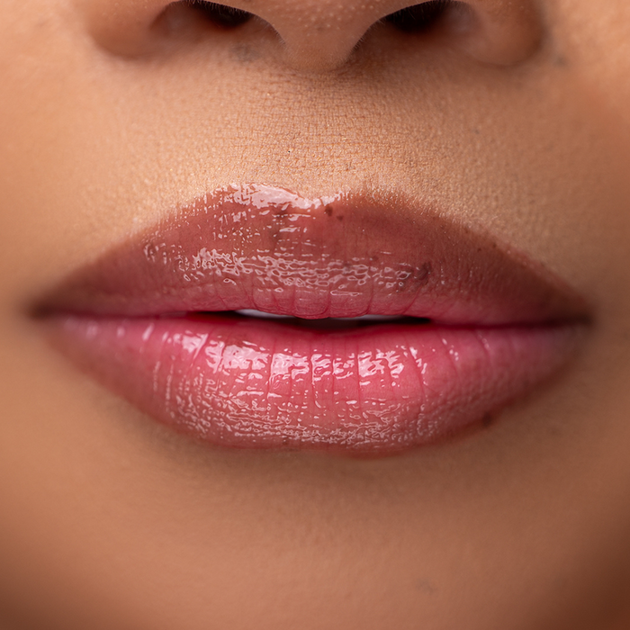 Close-up of LippEase Tinted Lip Treatments Rich showing glossy burgundy high shine finish on light skin tone.