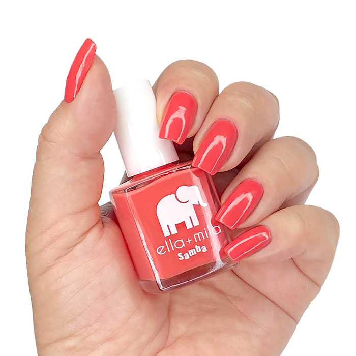 One in a Melon coral red nail polish manicure on a light skin tone with the bottle