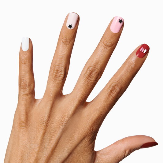 Hand with nails featuring SAY IT WITH BUBBLE LETTERS nail art stickers in black, white, pink, and red shades on medium skin tone