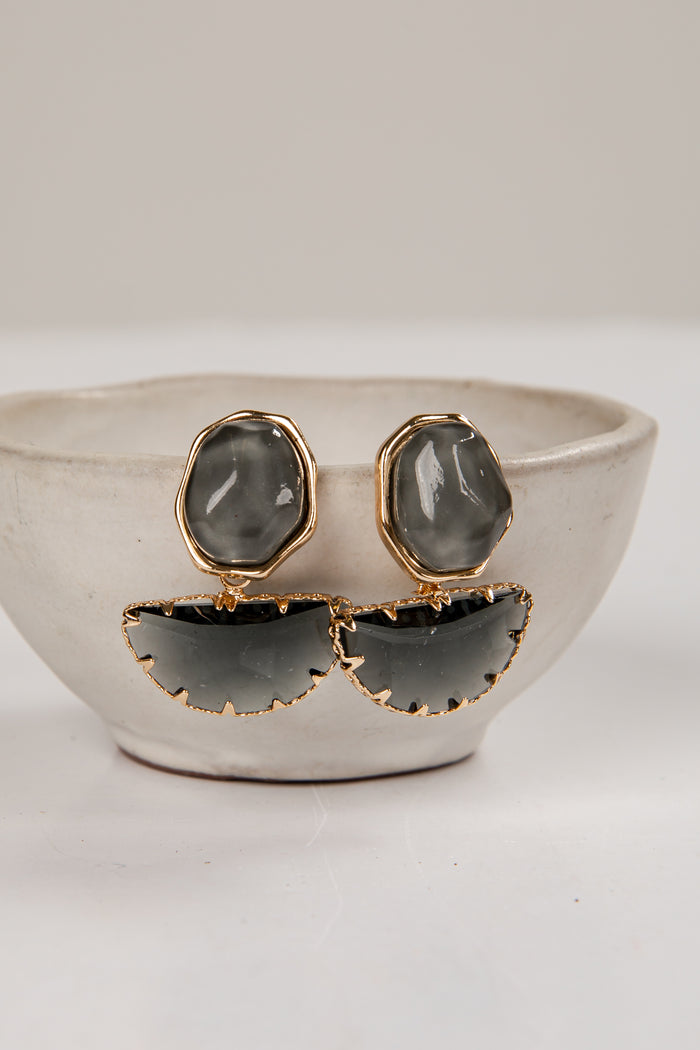 Pair of earrings with gold and gray design on a white surface