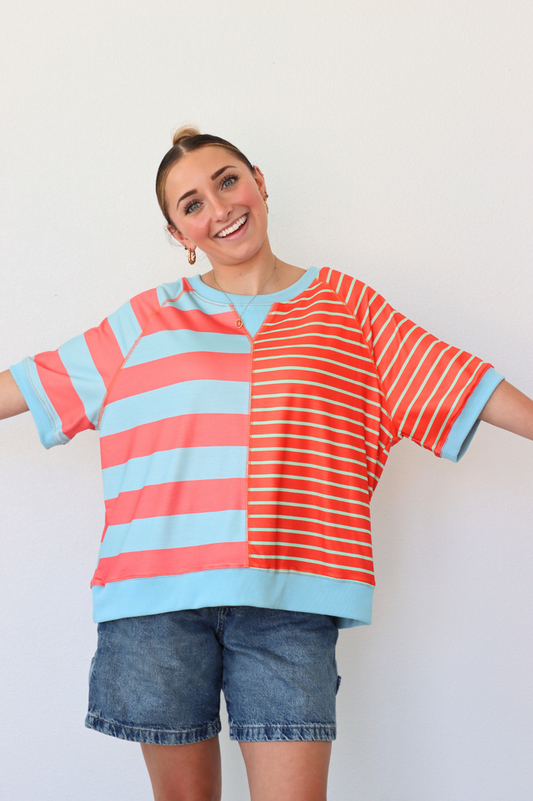 Person wearing a colorful striped shirt with a plain background
