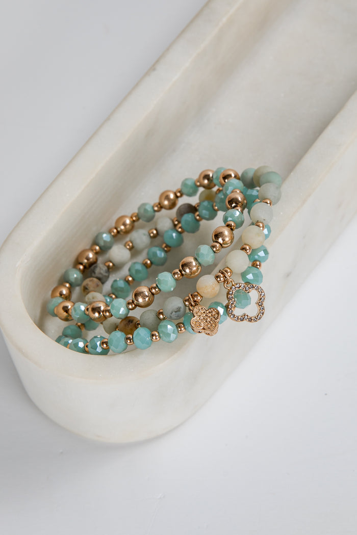 Turquoise and rose gold beaded bracelet on a white ceramic dish
