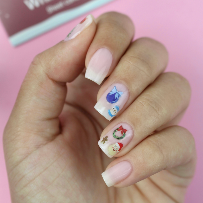 Toast to the Holidays ornament and gingerbread decals on a sheer pink manicure with the packaging